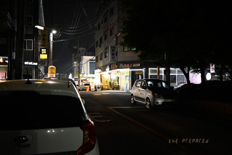 어두운 밤, 자동차와 건물, 가로등 불빛이 어우러진 아산의 한적한 골목길 풍경 사진입니다.