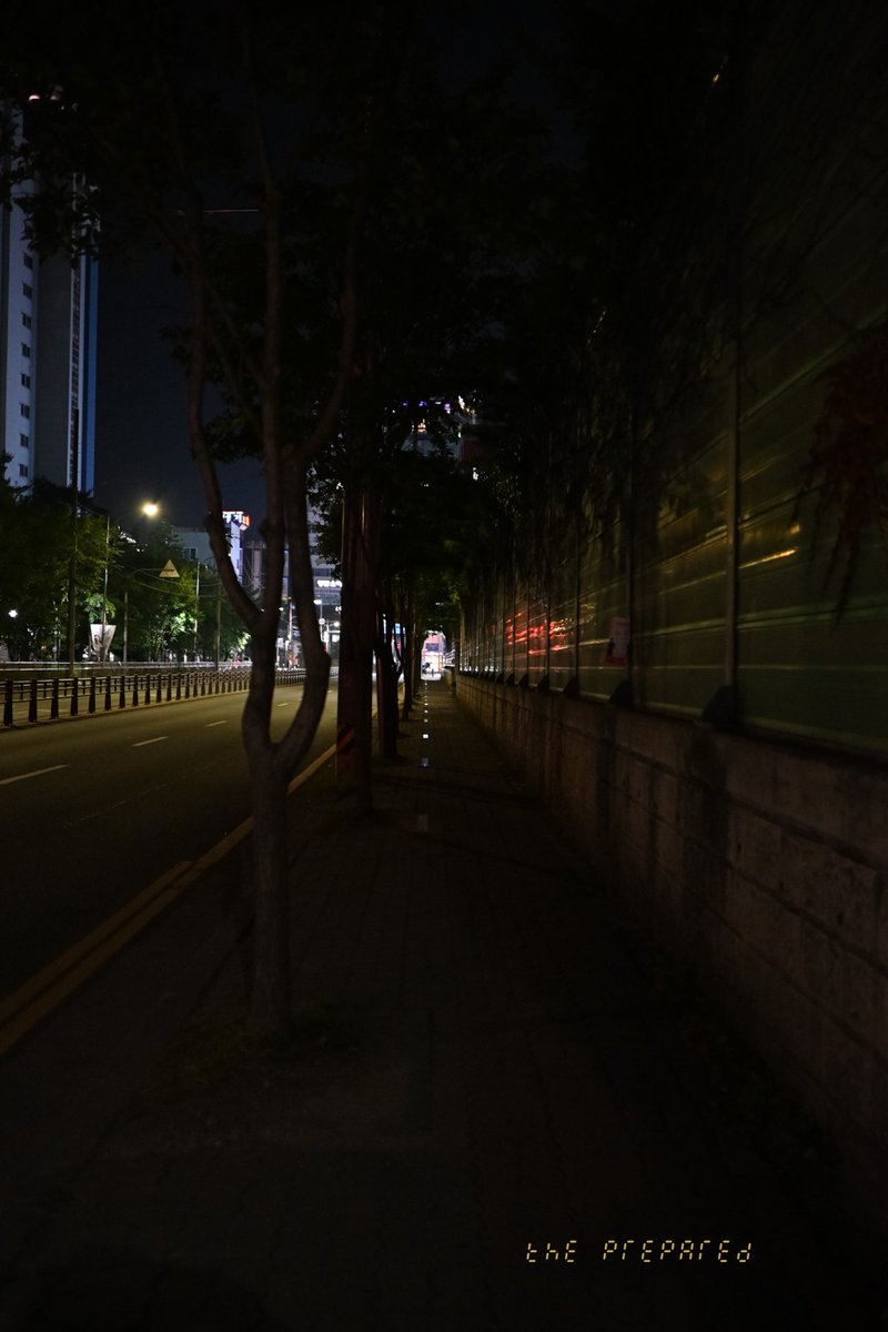 아산시 도심의 어두운 밤거리를 담은 사진. 가로등 불빛이 희미하게 비추는 텅 빈 도로와 인적이 드문 인도가 보인다.