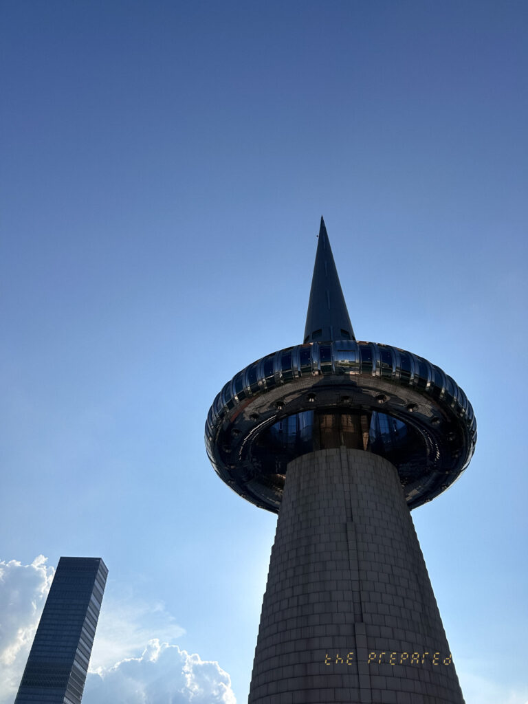 한빛탑과 대전 엑스포 과학공원을 배경으로 찍은 하늘 사진입니다. 위에서 올려다본 탑의 아래쪽을 찍었으며, 탑 상단의 원반 모양 플랫폼과 하늘을 향해 솟은 첨탑이 보입니다.