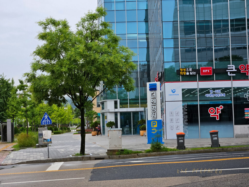 1층에 약국이 있는 큰 건물의 사진입니다.