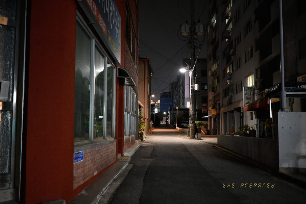 어두운 밤, 건물, 가로등 불빛이 어우러진 아산의 한적한 골목길 풍경 사진입니다.