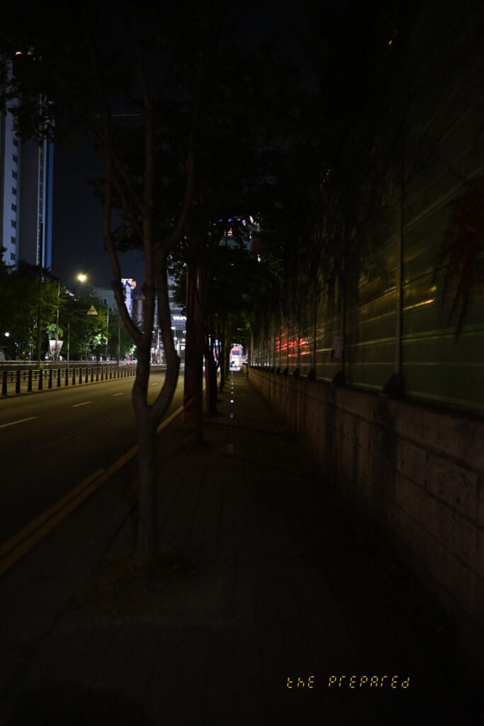 아산시 도심의 어두운 밤거리를 담은 사진. 가로등 불빛이 희미하게 비추는 텅 빈 도로와 인적이 드문 인도가 보인다.